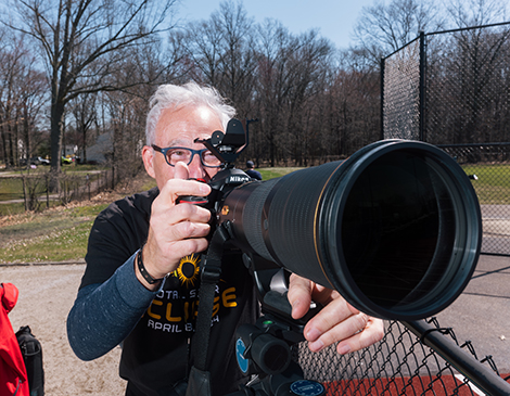 A man prepares to photograph the eclipse