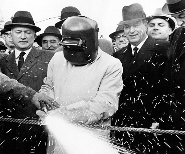 Mayor Anthony Celebrezze firing up an acetylene torch and cutting through a one-inch cable.