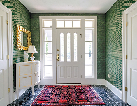 The simple front door with green walls surrounding it.