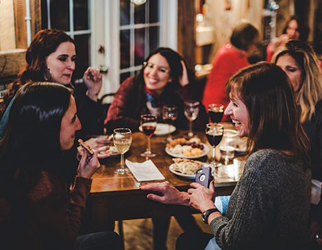 Women enjoying wine and pizza