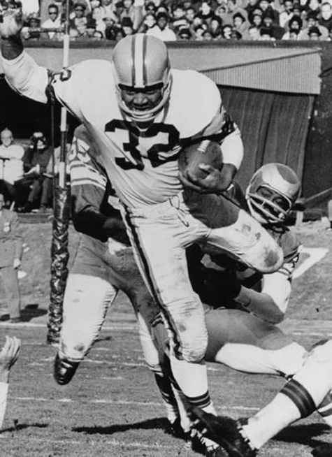 Cleveland Browns halfback Jim Brown carries the ball past Philadelphia Eagles defenders in a game from the 1964 NFL championship season