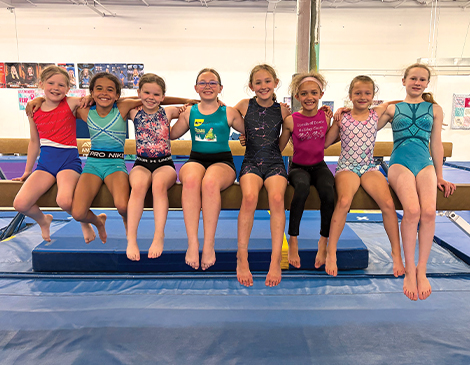 East_Article-Eastlake-Gymnastics Gymnastics students sitting on beam