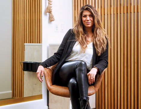 west23_stylist_article Christine Dopoulos sitting in a stylist chair at Foxy Salon