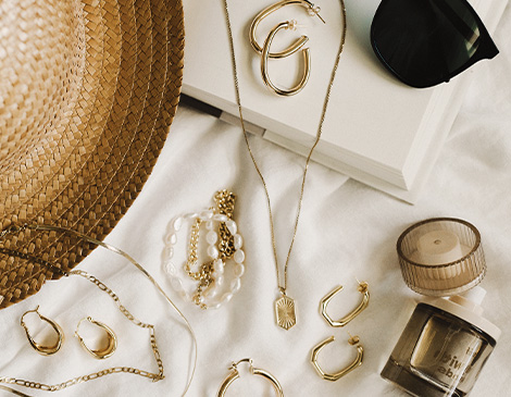 west23_things-we-love_article an assortment of gold jewelry laid on a white background