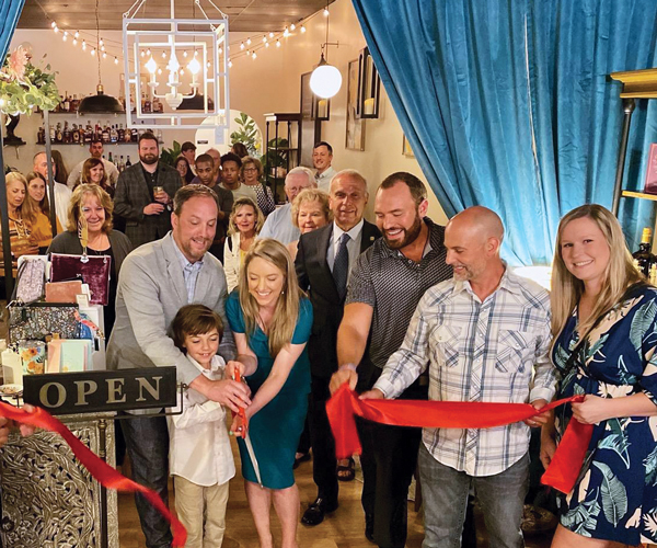 A group of people standing around a ribbon cutting ceremony