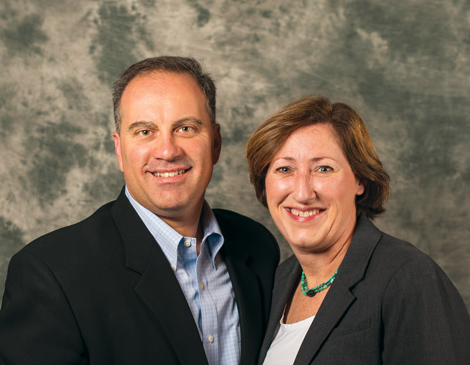 a couple in suits smiling