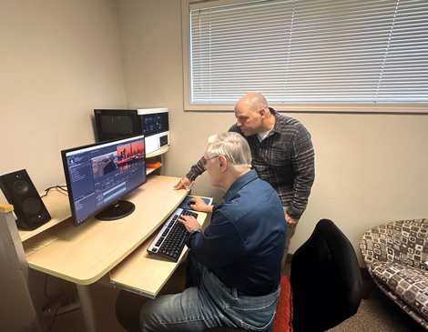 A BAT employee helping a man edit video footage