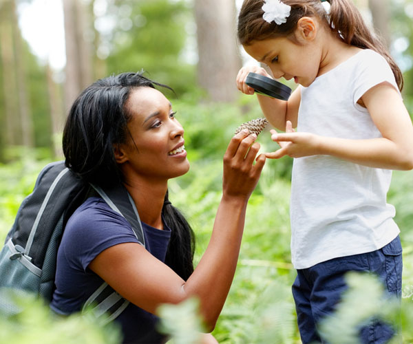 Woman and Child Looking at Pine Cone