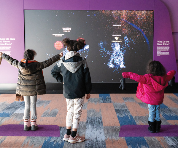 three kids interacting with an exhibit at the Cleveland Museum of Natural History