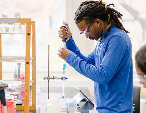 A student in a lab performing an experiment