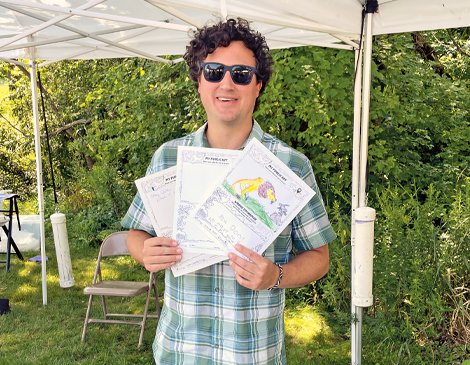 470x365_Article-2 Man holding copies of Green Visionary Activity Book