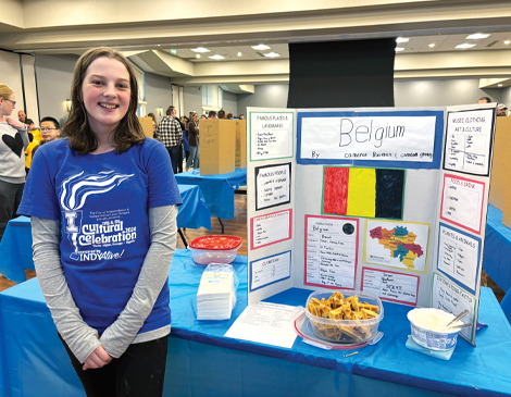 470x365_Article-6 Student standing in front of Belgium display at cultural fair