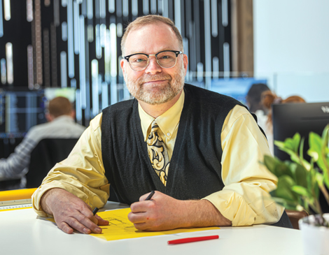 Jim āJPā Ptacek sitting at desk