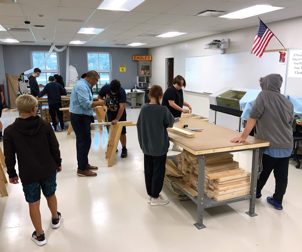 high school students in a workshop learning to use tools