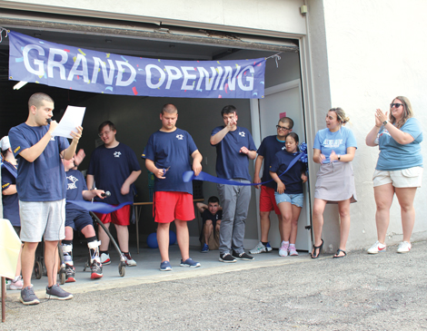 able-not-label-article a group of students gathered under a banner that reads "Grand Opening"