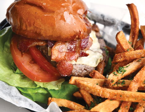 a close-up of a burger and fries in a plastic black tray