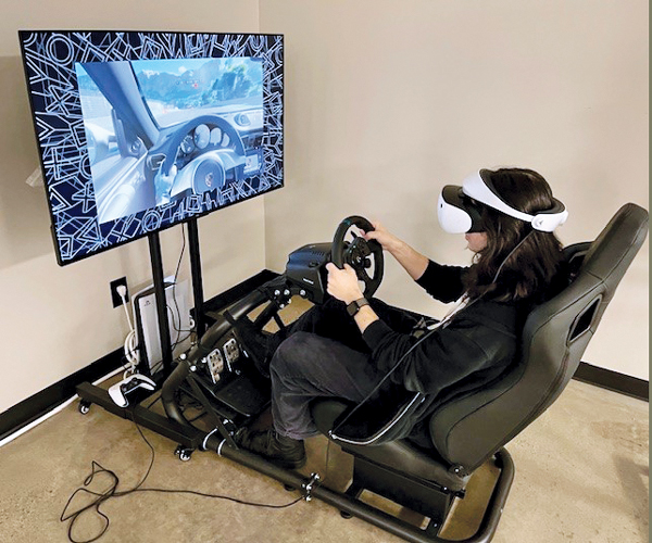 A student driving a car using a virtual reality setup