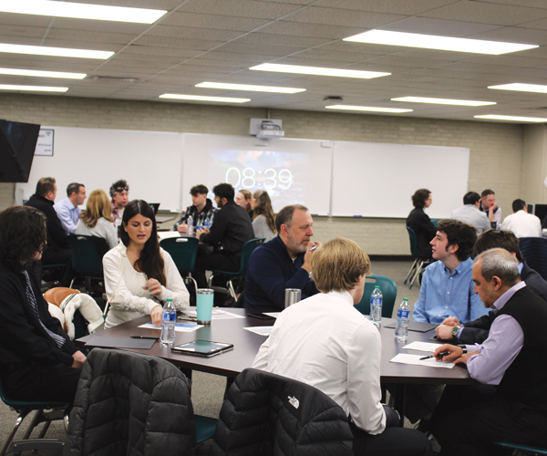 1-strongsville-high-school-career-exploration-program-article a group of students and adults talking around a few tables