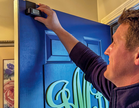 A firefighter installing a lock box on someone's front door