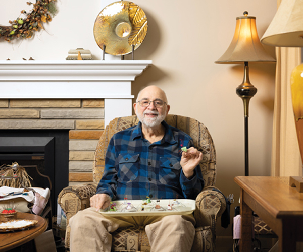 Paul Johanni holding up a spider that he made