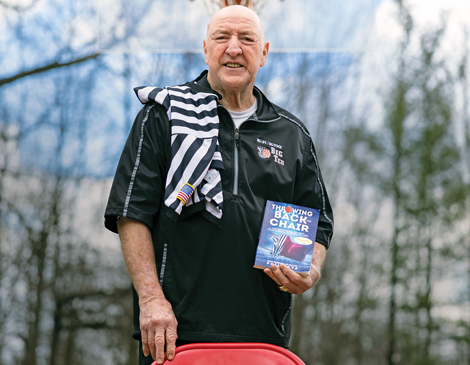 westlake-phil-bova-article Phil Bova smiling while holding his book "Throwing Back the Chair"