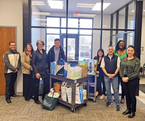 A group of Willoughby Western Lake County chamber members standing with bags of donations